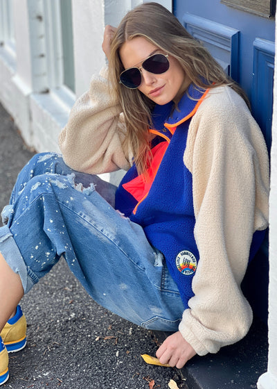 Hammill & Co super comfy and cozy new Alpes panelled polar fleece  with half button front in denim blue with raglan sleeves in a warm natural colour. Featuring contrast coloured front panel and orange coloured piping down the front. 