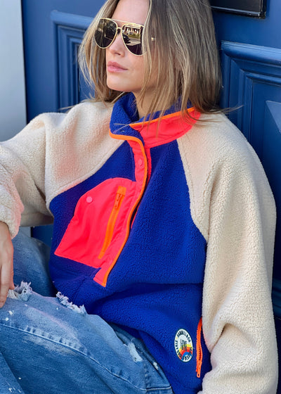 Hammill & Co super comfy and cozy new Alpes panelled polar fleece  with half button front in denim blue with raglan sleeves in a warm natural colour. Featuring contrast coloured front panel and orange coloured piping down the front. 