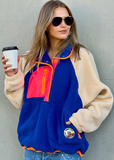 Hammill & Co super comfy and cozy new Alpes panelled polar fleece  with half button front in denim blue with raglan sleeves in a warm natural colour. Featuring contrast coloured front panel and orange coloured piping down the front. 