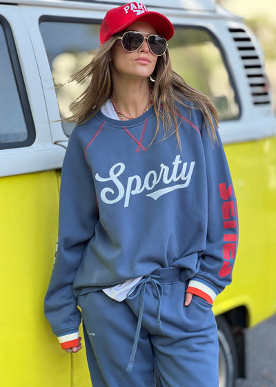 Hammill & Co New Sporty sweat is in a soft brushed fleece fabric in a washed denim blue colour with stripe rib cuffs. Cute printed Sporty print on the front and Word Series down each sleeve in washed white and Retro 1975 print across the back.