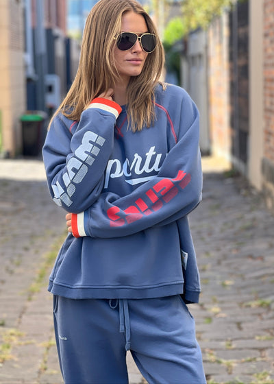 Hammill & Co New Sporty sweat is in a soft brushed fleece fabric in a washed denim blue colour with stripe rib cuffs. Cute printed Sporty print on the front and Word Series down each sleeve in washed white and Retro 1975 print across the back.