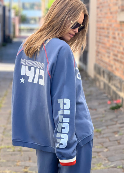 Hammill & Co New Sporty sweat is in a soft brushed fleece fabric in a washed denim blue colour with stripe rib cuffs. Cute printed Sporty print on the front and Word Series down each sleeve in washed white and Retro 1975 print across the back.
