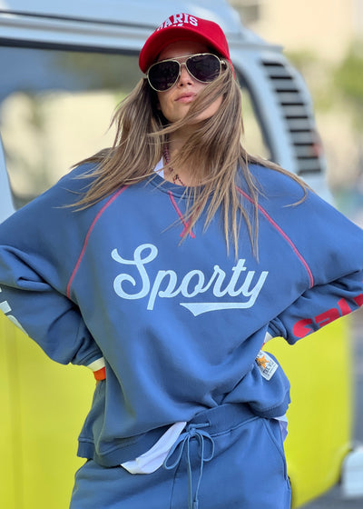 Hammill & Co New Sporty sweat is in a soft brushed fleece fabric in a washed denim blue colour with stripe rib cuffs. Cute printed Sporty print on the front and Word Series down each sleeve in washed white and Retro 1975 print across the back.