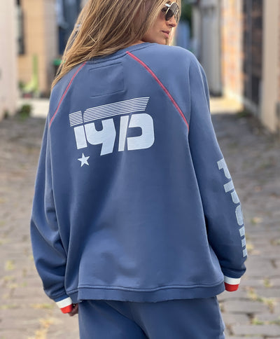Hammill & Co New Sporty sweat is in a soft brushed fleece fabric in a washed denim blue colour with stripe rib cuffs. Cute printed Sporty print on the front and Word Series down each sleeve in washed white and Retro 1975 print across the back.