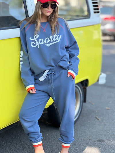 Hammill & Co New Sporty sweat is in a soft brushed fleece fabric in a washed denim blue colour with stripe rib cuffs. Cute printed Sporty print on the front and Word Series down each sleeve in washed white and Retro 1975 print across the back.