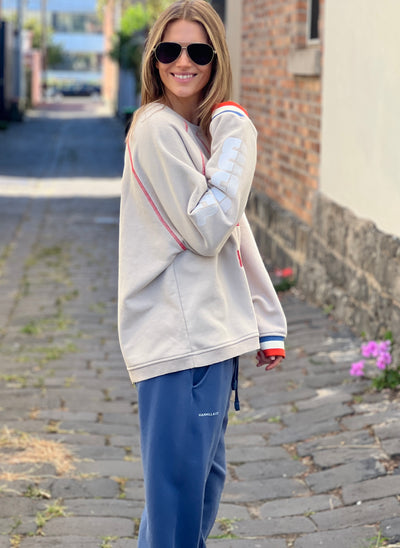 Hammill & Co New Sporty sweat is in a soft brushed fleece fabric in a washed natural colour with stripe rib cuffs. Distressed Red 75 print on the front and Word Series down each sleeve in washed white and Retro 1975 print across the back.
