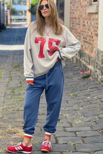 Hammill & Co New Sporty sweat is in a soft brushed fleece fabric in a washed natural colour with stripe rib cuffs. Distressed Red 75 print on the front and Word Series down each sleeve in washed white and Retro 1975 print across the back.