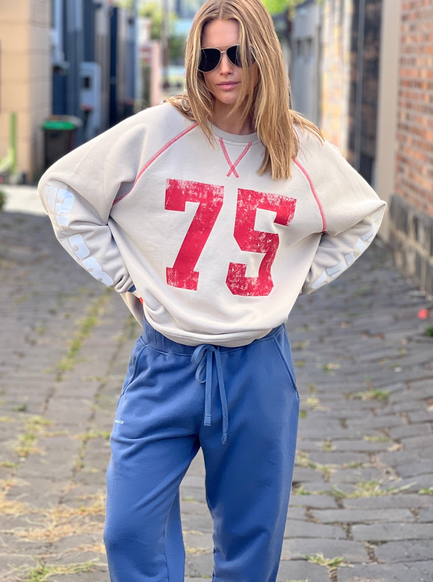 Hammill & Co New Sporty sweat is in a soft brushed fleece fabric in a washed natural colour with stripe rib cuffs. Distressed Red 75 print on the front and Word Series down each sleeve in washed white and Retro 1975 print across the back.