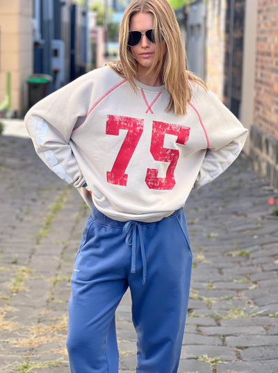 Hammill & Co New Sporty sweat is in a soft brushed fleece fabric in a washed natural colour with stripe rib cuffs. Distressed Red 75 print on the front and Word Series down each sleeve in washed white and Retro 1975 print across the back.