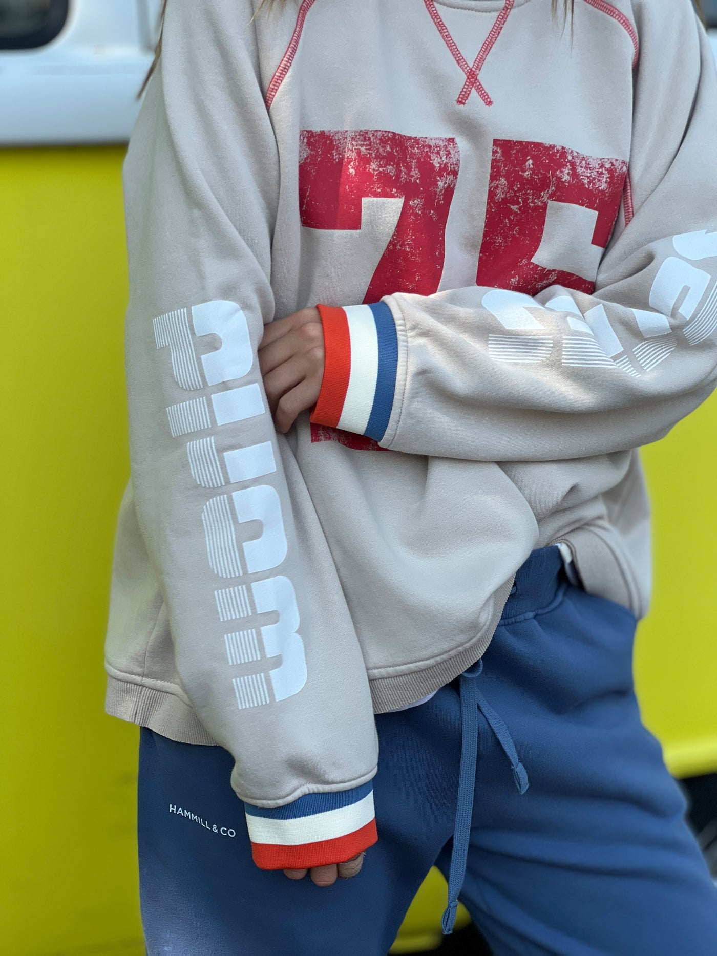 Hammill & Co New Sporty sweat is in a soft brushed fleece fabric in a washed natural colour with stripe rib cuffs. Distressed Red 75 print on the front and Word Series down each sleeve in washed white and Retro 1975 print across the back.