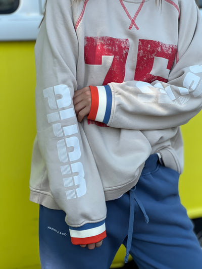 Hammill & Co New Sporty sweat is in a soft brushed fleece fabric in a washed natural colour with stripe rib cuffs. Distressed Red 75 print on the front and Word Series down each sleeve in washed white and Retro 1975 print across the back.