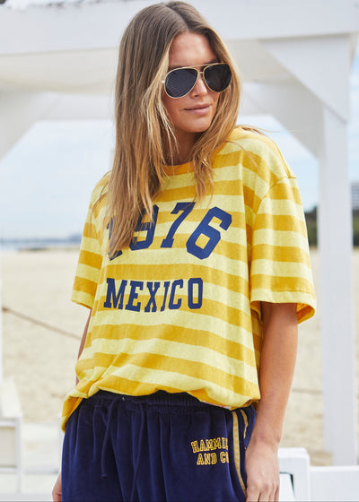 Hammill & Co Slouchy crew neck tee in a soft yellow and mustard stripe jersey with navy retro Mexico print on the front. Looks great worn back with the velour pants and shorts!