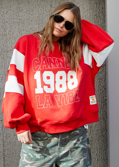 Hammill & Co Cannes 1988 red sweat panelled sweat with relaxed raglan sleeve and contrast panels with slight puff sleeve. The sweat is in a gorgeous washed red with natural panels and front chest print.