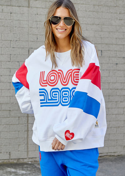 Hammill & Co LOVE 1988 white panelled sweat with relaxed raglan sleeve and contrast panels in blue and red with slight puff sleeve. 