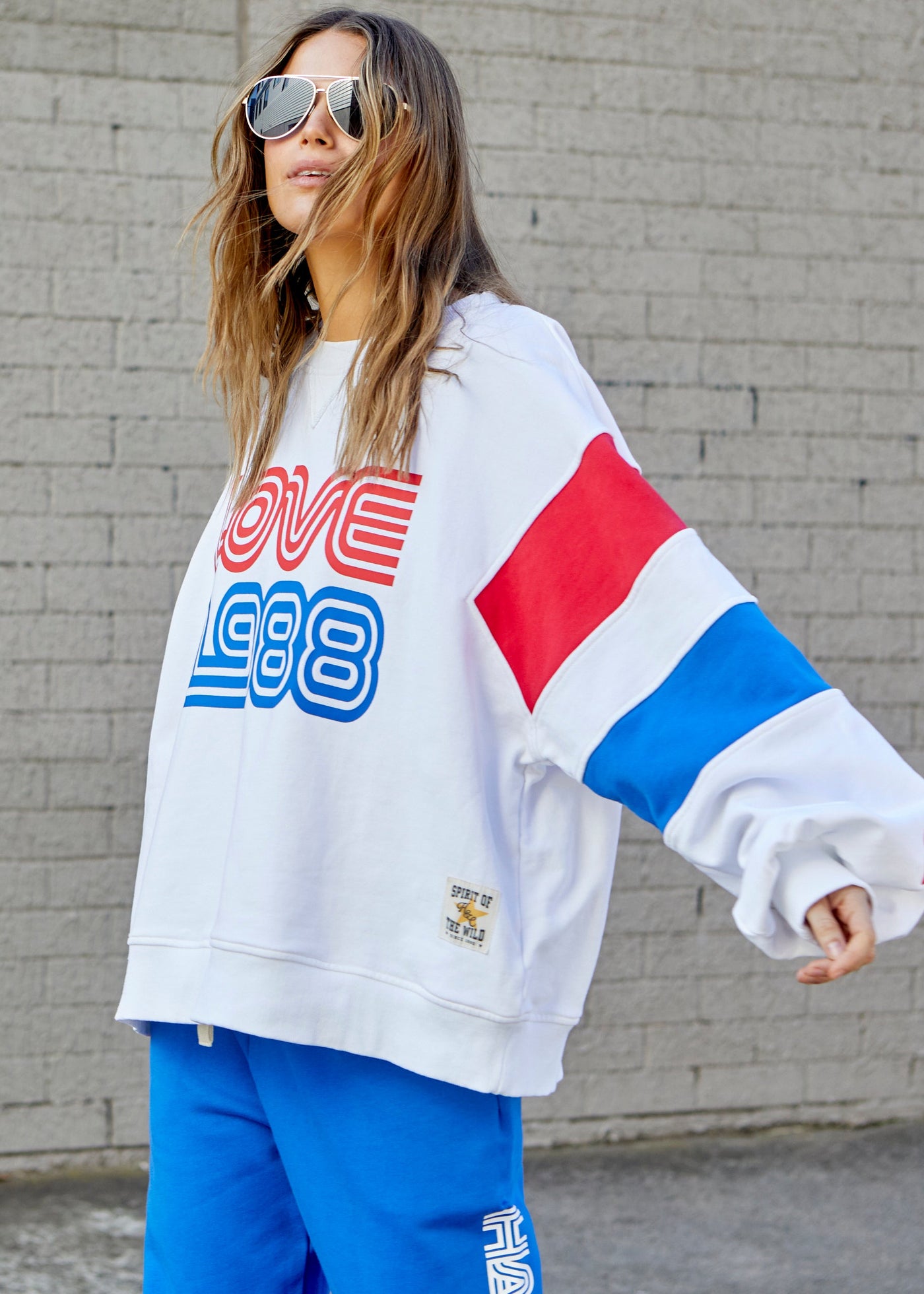 Hammill & Co LOVE 1988 white panelled sweat with relaxed raglan sleeve and contrast panels in blue and red with slight puff sleeve. 