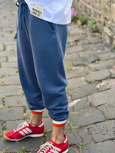 Hammill & Co Fleecy denim blue track pant with stripe cuffs, elastic waist band with draw cord, 7/8 length and small Hammill and Co logo on the right hip. Looks great worn back with the matching sweat.