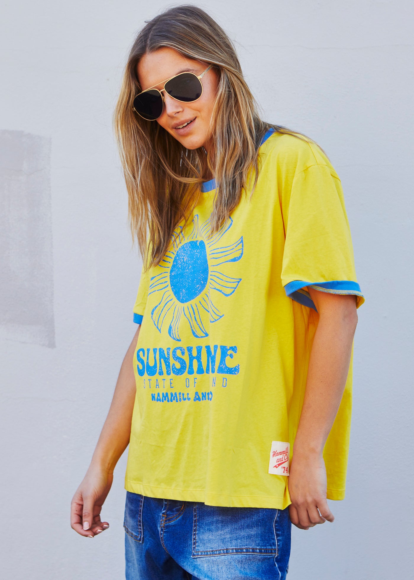 Hammill & Co Sunshine State of Mind tee in a slouchy V neck style in a soft bright yellow slub jersey with royal blue print on the front .