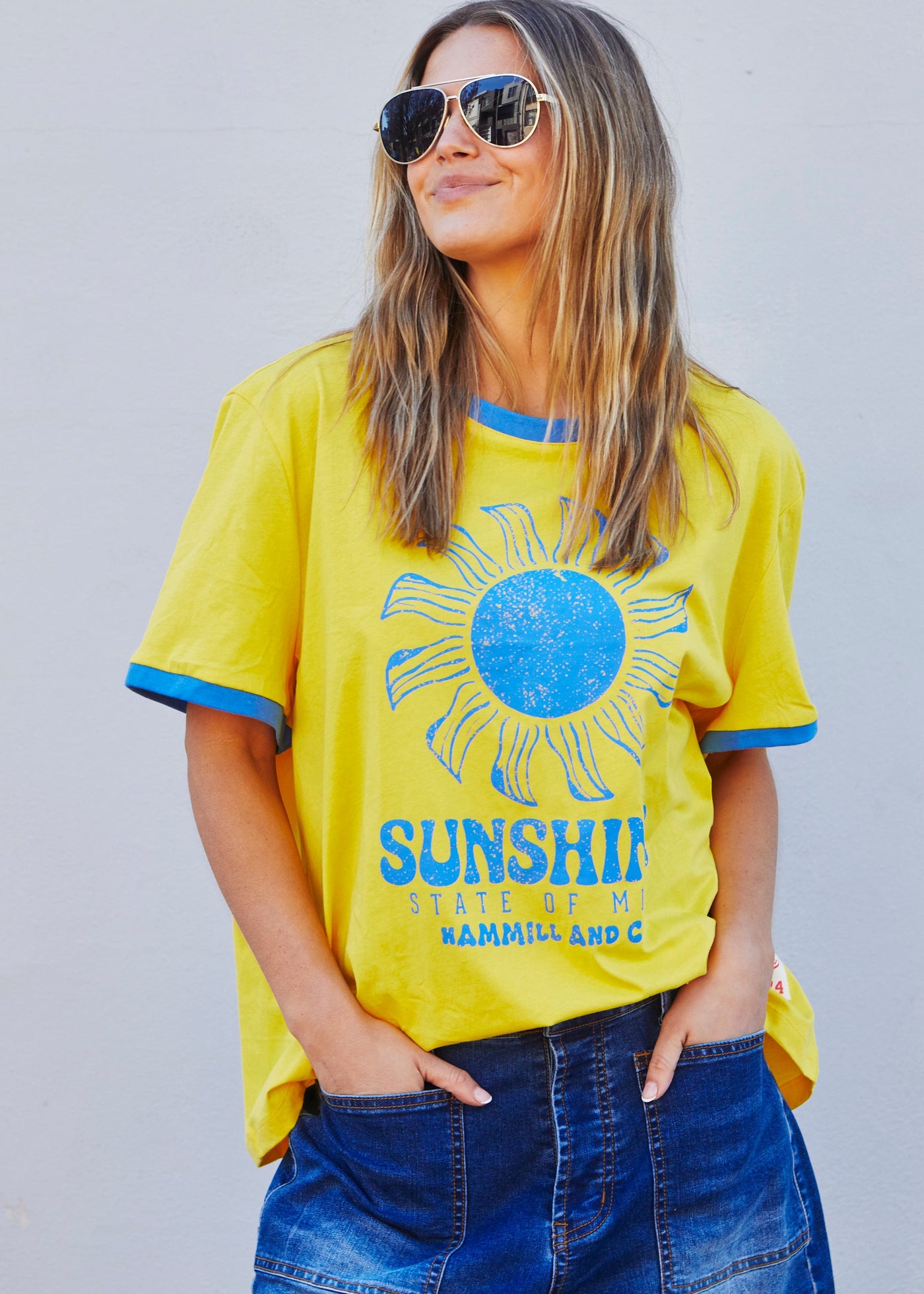 Hammill & Co Sunshine State of Mind tee in a slouchy V neck style in a soft bright yellow slub jersey with royal blue print on the front .