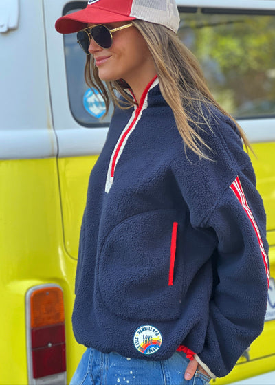 Hammill & Co Soft and cozy Navy 1/2 zip polar fleece sweat. Featuring stripe tape down each sleeve, contrast placket and front zipper, slouchy pockets with red zips, adjustable waistband with elastic and toggle and higher neck style for extra warmth.