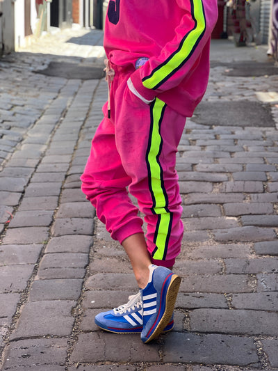Hammill & Co  Sporty velour track pants in our best selling hot pink. Featuring stripe  none and navy tape down each leg, natural draw cord with elastic waist and woven badge on the back pockets.