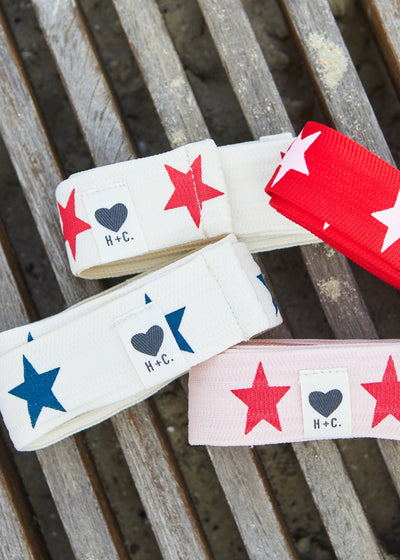 Hammill & Co Stretch natural tape with red stars printed on one side and the other side plain. The end has small H+C badge.