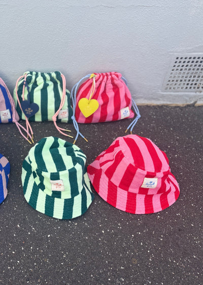 Hammill & Co bold striped bucket hat is pure summer happiness. Made from soft terry towelling in vibrant green/mint stripes, it adds a playful pop to any outfit. 