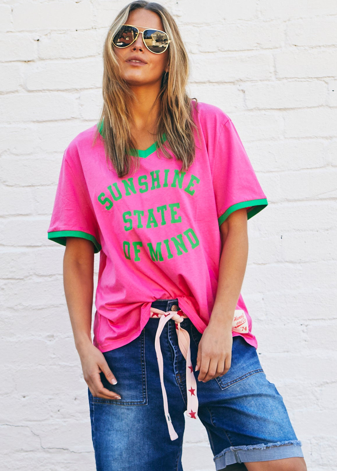 Hammill & Co Slouchy V neck tee in a soft hot pink slub jersey with green print on the front . Contrast green rib&nbsp; Looks great worn back with our denim shorts or jeans!