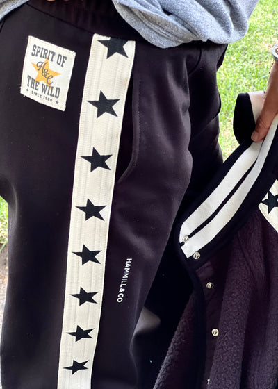 Hammill & Co wider leg street pant is a new addition to our track pant offering, an easy pull versatile style that is super comfy yet super stylish which can be dressed up or down!
Relaxed Varsity wider leg casual track pant with contrast tape down both legs with stars.