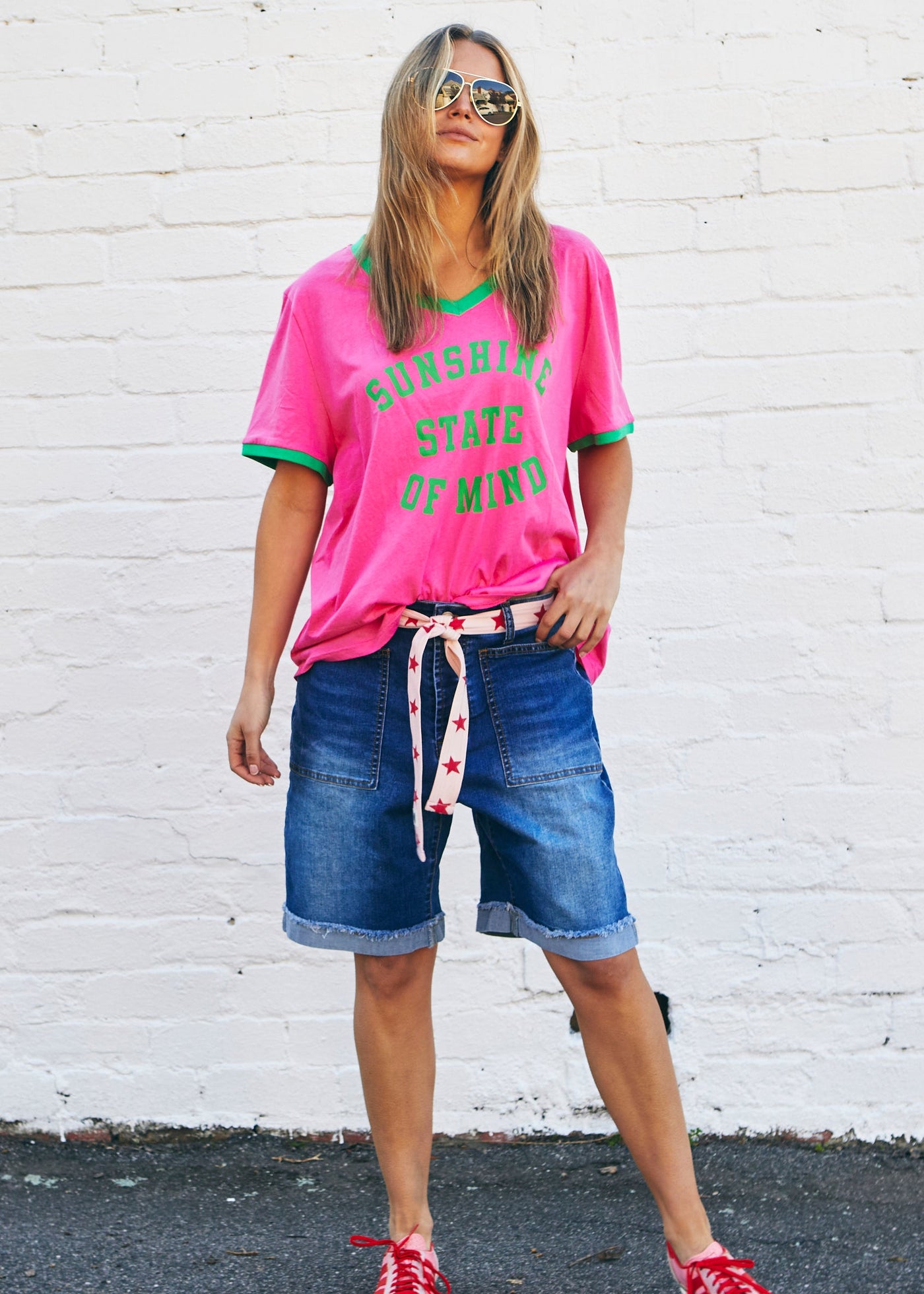 Hammill & Co A pair of longer-length darker denim stretch shorts with a relaxed fit. They have front pockets, a raw rolled hem, and sit mid-thigh. 